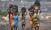 Local women carry coal taken from open cast coal field at Dhanbad district in Jharkhand