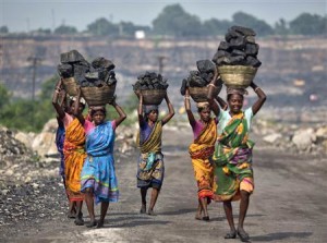 Local women carry coal taken from open cast coal field at Dhanbad district in Jharkhand